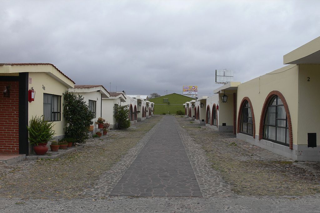 Bungalós del Hotel Colonial con arcos de ladrillo y andador empedrado